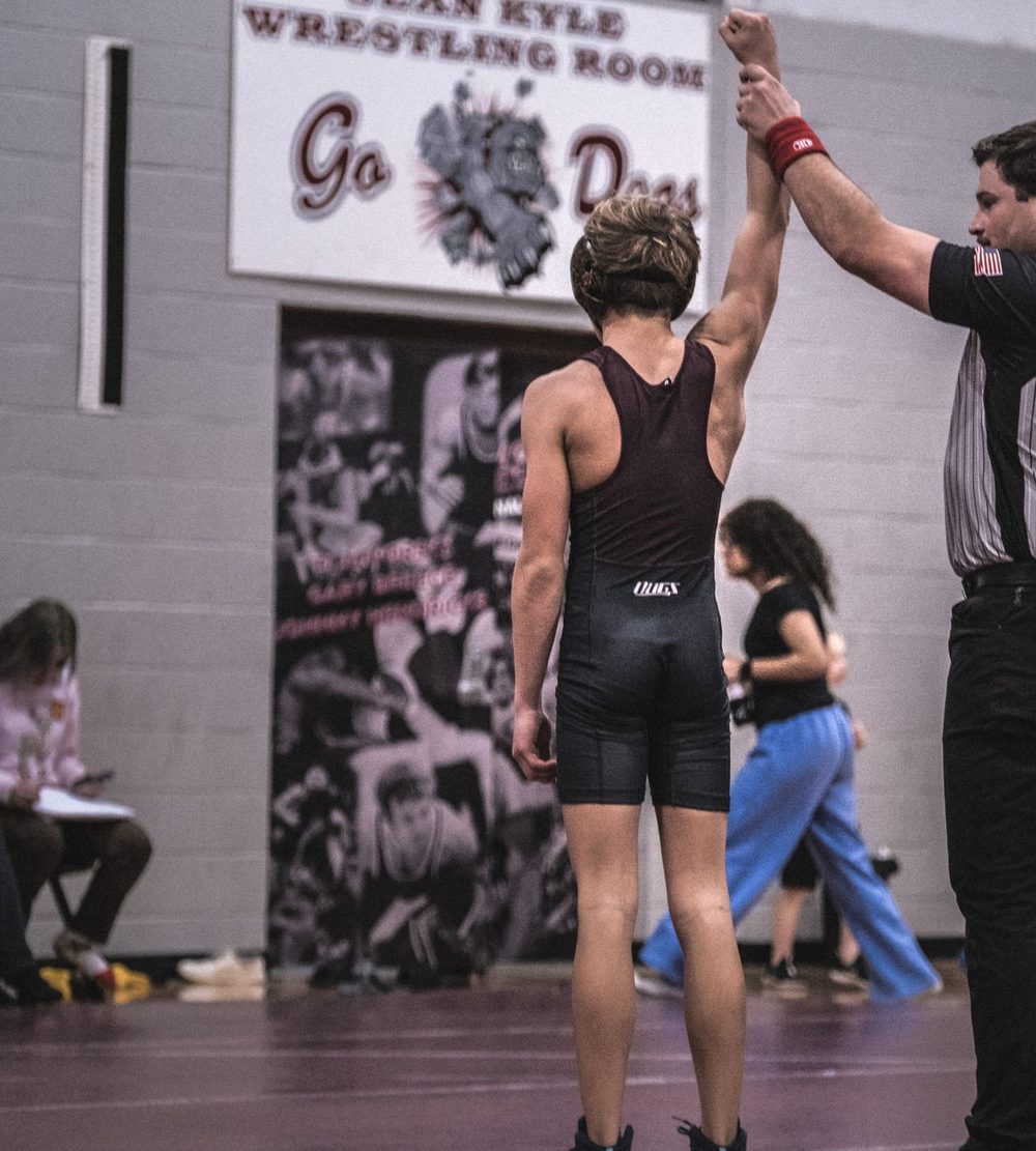 An Edmond Memorial wrestler gets his hand raised after a win