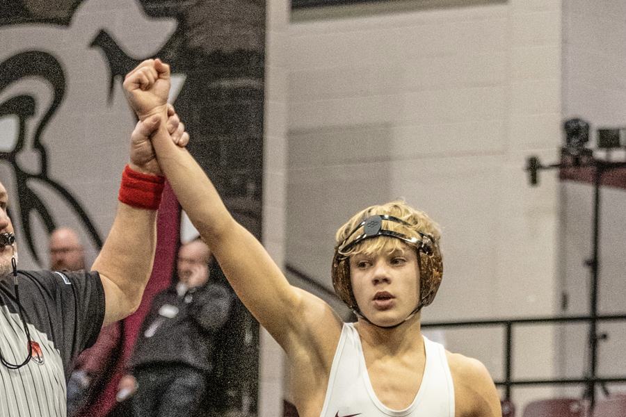An Edmond Memorial wrestler gets his hand raised after a win